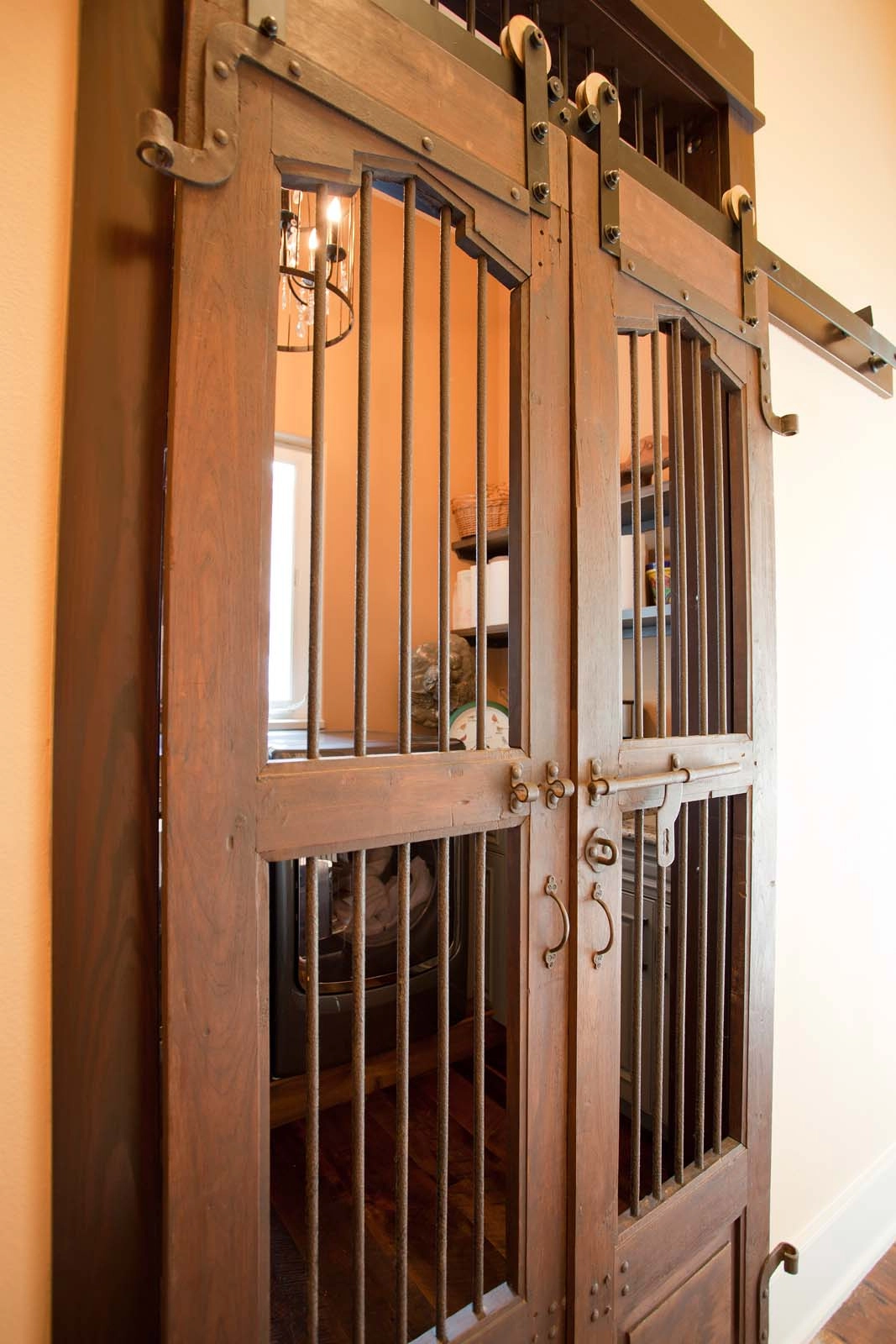 Laundry room rustic wooden barn doors with metal accents in a luxurious Mediterranean custom home by architect Ben Butera.