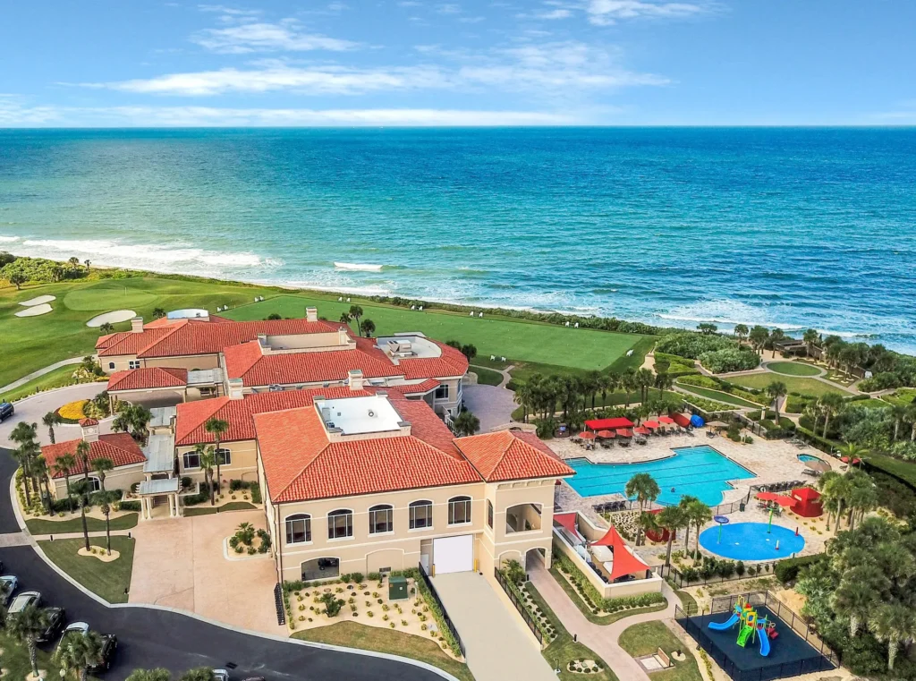 Hammock Dunes Club and Links Golf Course Aerial View 5- Drone shot of exclusive Hammock Dunes club oceanfront gated community clubhouse, remodeled by architect Benjamin P. Butera.