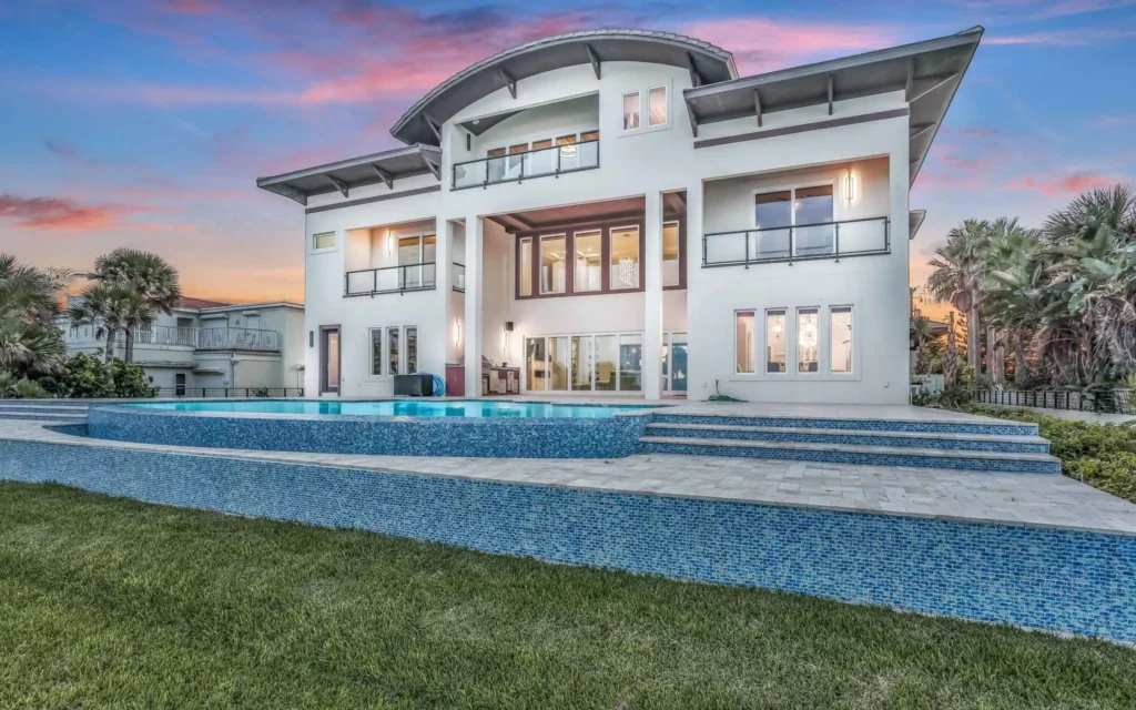 Modern home by Ben Butera luxury home architect with curved roof, balcony and glass doors for ocean views and outdoor living.