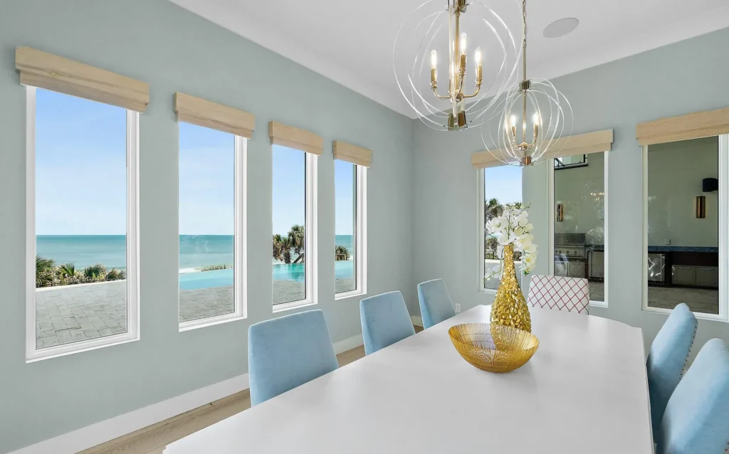 Top selling oceanfront custom home dining room with pool, outdoor kitchen and ocean view by Ben Butera Florida architect.