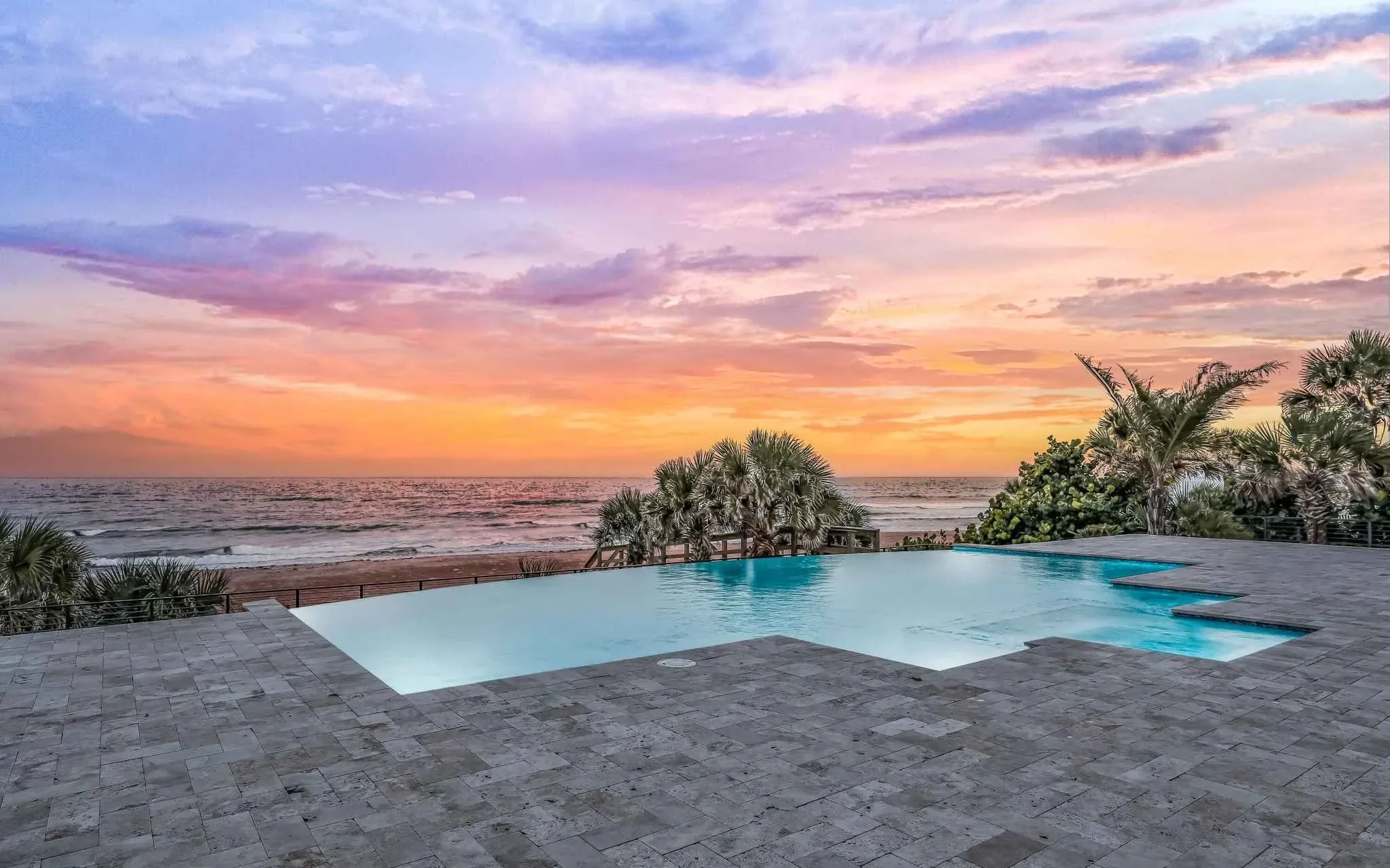 Luxury oceanfront retreat with zero-edge pool by best home builders and Ben Butera signature design to add property value.