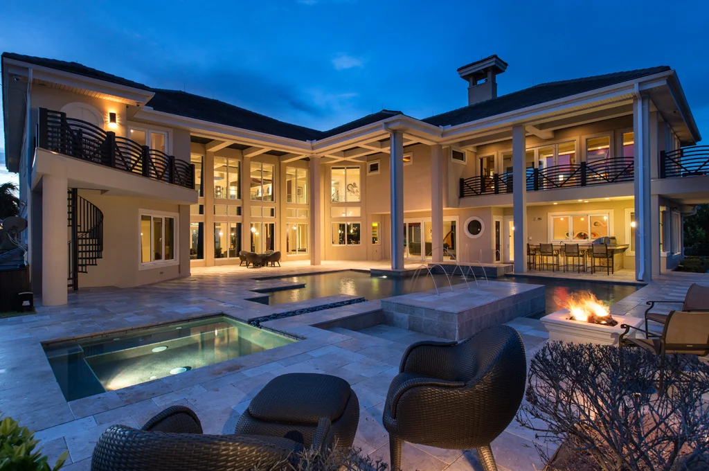 Night View Back of Eclectic Oceanfront Home Luxury custom home with large windows with ocean view and swimming pool in Daytona Beach Shores by Ben Butera design studio.