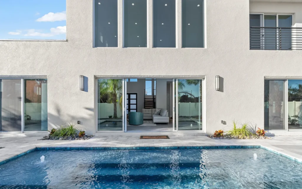 Sustainable Contemporary Pool and Yard View Indoor Outdoor Living Scaled Sustainable design contemporary home with pool and large windows for indoor-outdoor living, a Benjamin P. Butera green design