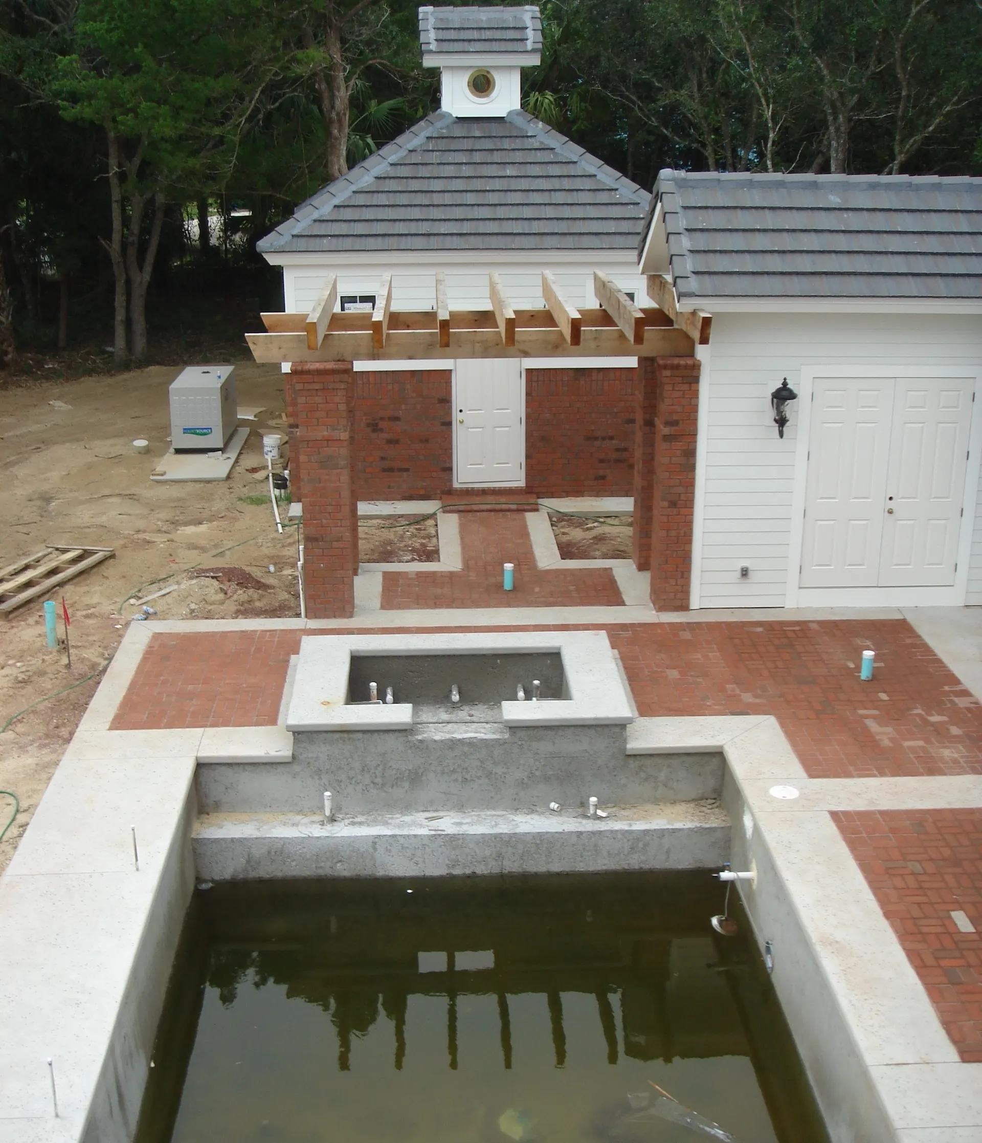 Building site of custom home by architect Benjamin P. Butera featuring pump house, pergola, hot tub and pool construction